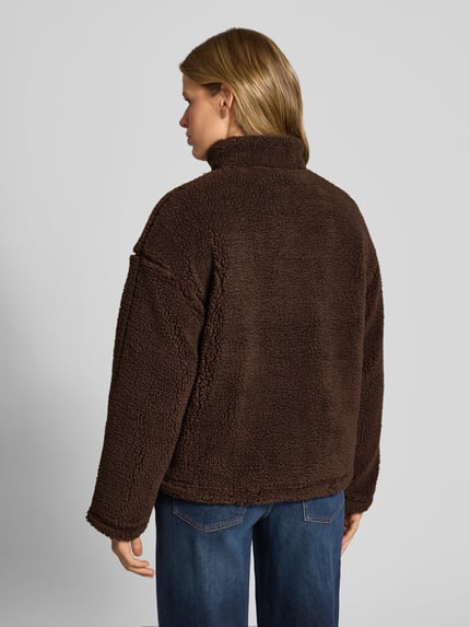 Frauenmodel trägt Teddyjacke mit Stehkragen von REVIEW in dunkelbraun, Regular Fit, Fleece, Rückenansicht, Kontext: Damen Fleecejacke, Teddyfell, Reißverschluss, Rückenlänge 66 cm, Schulterbreite 48 cm, Brustweite 56 cm, Ärmellänge 57 cm. Ganzkörperansicht Rückansicht