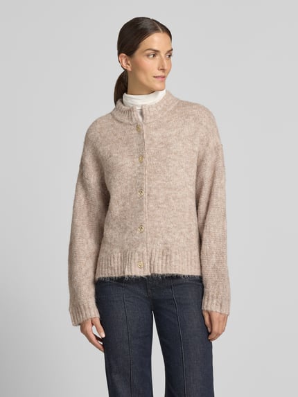 Frauenmodel trägt Cardigan mit Stehkragen Modell 'Taura' von Neo Noir in Beige, grobe Strickstruktur, Knopfleiste, Regular Fit, Ganzkörperansicht von vorne.