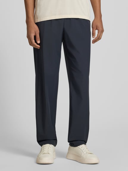 Męski model trägt spodnie 'Hose mit elastischem Bund und Gesäßtaschen' von Armani Exchange, mieszanka materiałów z dodatkiem streczu, krój relaxed fit, elastyczny pas, kieszenie z tyłu, szerokość w rozmiarze 32: 40 cm, długość wewnętrzna nogawki w rozmiarze 32: 79 cm, ciemnoniebieskie, gładka tekstura, Ganzkörperansicht von vorne.