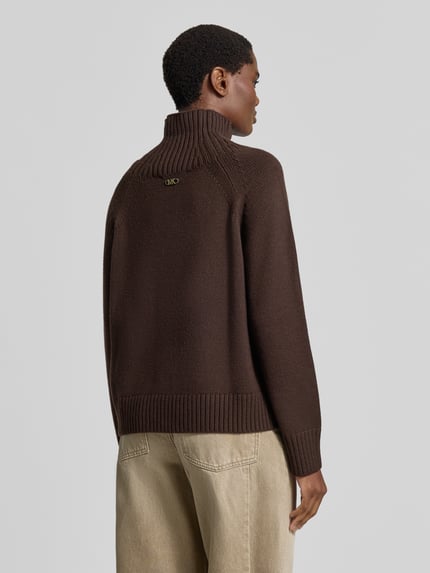 Vrouwenmodel draagt gebreide pullover uit zuiver linnen van MICHAEL Michael Kors, los model, opstaande kraag, Raglanmouwen, ribboorden, ruglengte maat S 67 cm, mouwlengte maat S 48 cm, donkerbruin, gestructureerde textuur, geheel zicht van achteren.