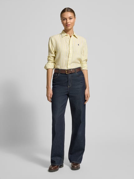 Kobiece model prezentuje bluzkę koszulową z lnu o luźnym kroju z kołnierzykiem koszulowym, listwą guzikową i wyhaftowanym logo marki Polo Ralph Lauren, długość tyłu 70 cm, długość rękawa 62 cm, przód – całopostaciowy widok.