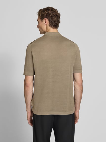 Männermodel trägt Regular Fit Poloshirt aus reiner Baumwolle - Marc O'Polo × DFB Travel Collection, unifarben, Stricktextur, Ganzkörperansicht Rückansicht.