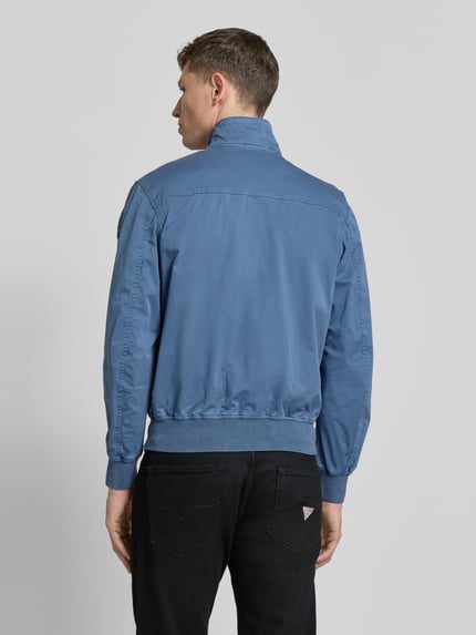 Männermodel trägt Jacke mit Tweewegritssluiting model 'Badger' van Blauer Usa in blauw, mix van katoen en elastaan, regular fit, opstaande kraag, klepzakken, ruglengte maat M 64 cm, schouderbreedte 40 cm, borstwijdte 50 cm, mouwlengte 63 cm, ganzkörperansicht rückansicht.