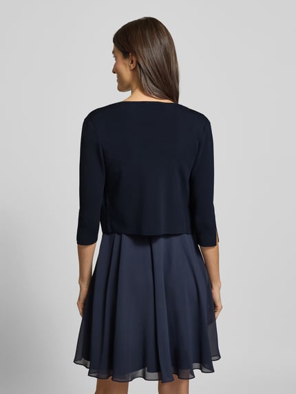 Frauenmodel trägt Regular Fit Bolero aus Viskose-Mix von Vera Mont, Optik: Unifarben, Schalkragen, Cropped, geschlitzter Ärmelabschluss, Ganzkörperansicht Rückansicht.