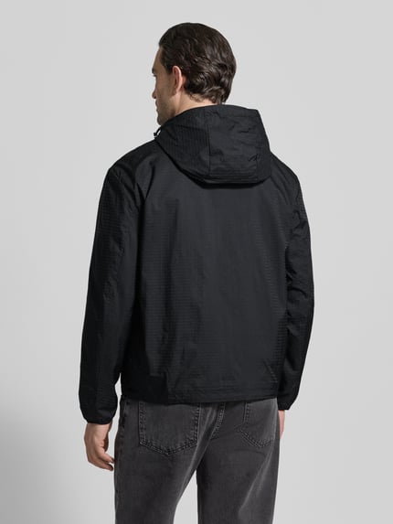 Männermodel trägt schwarze Jacke mit Zweiwege-Reißverschluss von Emporio Armani, Kapuze, Reißverschlusstaschen, Ganzkörperansicht Rückansicht.