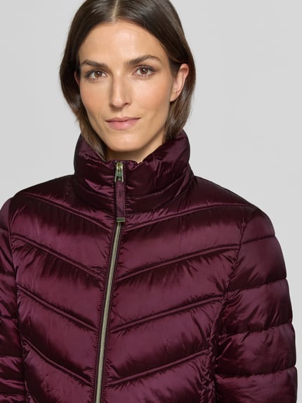 Männermodel trägt Steppmantel mit Zweiwege-Reißverschluss von Christian Berg Woman Selection in dunklem Violett, glatte Textur, krój slim fit, kaptur z troczkiem, kieszenie na zamek, szerokość w rozmiarze 36: 48 cm, długość tyłu: 83 cm, szerokość ramion: 40 cm, długość rękawa: 65 cm, nahaufnahme oberkörper.