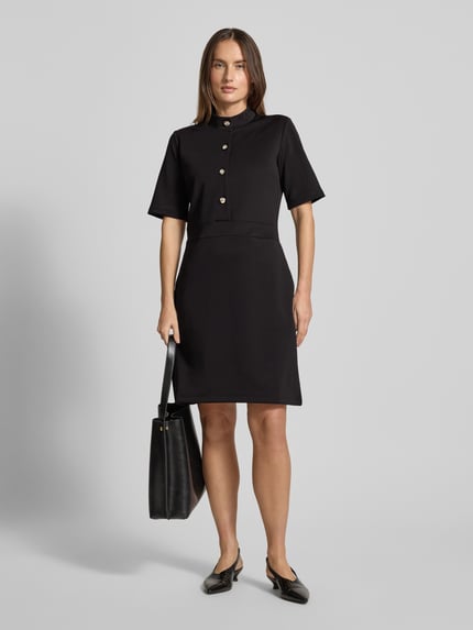 Kobiece modelka nosi czarne mini sukienkę z bawełnianym mixem, stójką i guzikami, JOOP! 'Kleid mit Stehkragen und Knopfleiste Modell Tibra', A-linia, krótki rękaw, widok całości z przodu.