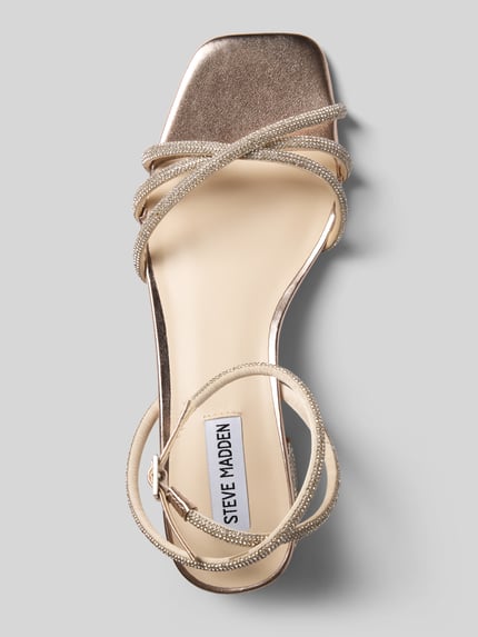Produktfoto, Sandaletten mit Allover-Strasssteinbesatz Modell 'Cerena' von Steve Madden, eckige Passform, offene Ferse, Absatzhöhe 5 cm, hellgoldene Farbe, glatte und funkelnde Texturen.