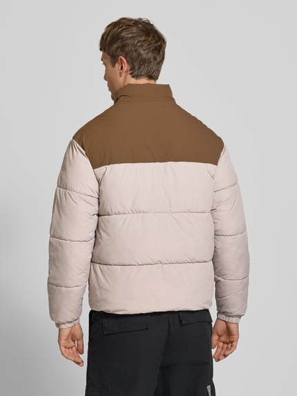 Männermodel trägt Steppjacke mit Stehkragen Modell 'RAZE' von JACK & JONES in Beige und Braun, Rückenansicht, Ganzkörperansicht Rückansicht. Reguläre Passform, Reißverschluss, Eingrifftaschen, samt glatter, wattierter Oberfläche, Rückenlänge, Schulterbreite, Brustweite und Ärmellänge laut Beschreibung.