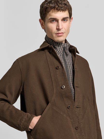 Męski model nosi Regular Fit Hemdjacke aus Baumwolle od Forét, brąz, ozdobne szwy, listwa guzikowa, krój z długim rękawem, szerokość ramion w rozmiarze M: 46 cm, długość tyłu w rozmiarze M: 73 cm, długość rękawów w rozmiarze M: 66 cm, bawełna, zbliżenie na górną część ciała.