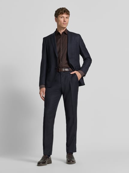 Männermodel trägt Slim Fit Business-Hemd mit Kentkragen von Christian Berg Men in dunklem Braun, Reine Baumwolle, Ganzkörperansicht von vorne.