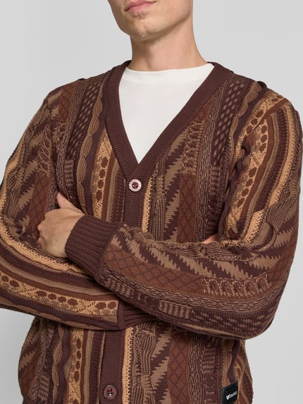 Männermodel trägt Relaxed Fit kardigan rozpinany aus reiner bawełna z Listwa guzikowa, Dekolt w serek, Detal z logo, COLUCCI, Długość tyłu w rozmiarze M: 67 cm, Długość rękawów w rozmiarze M: 67 cm, brązowe odcienie, wzór geometryczny, Nahaufnahme Oberkörper