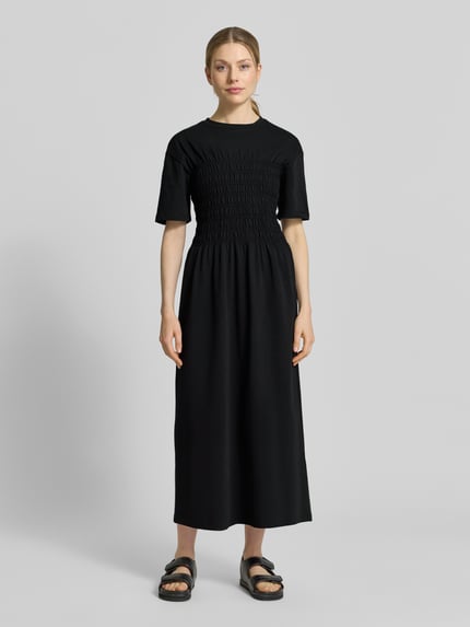 Frauenmodel trägt Midikleid mit Smok-Details von Jake*s Casual, Reine Baumwolle, Taillierter Schnitt, Rundhalsausschnitt, Ganzkörperansicht von vorne.