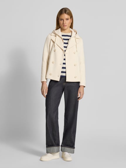 Vrouwenmodel draagt Regular Fit sweatjack met viscose-aandeel van s.Oliver RED LABEL in crème, met reverskraag, capuchon, dubbele knoopsluiting, lange mouw, zij-insteekzakken, materiaalverwerking sweat; volledig lichaamsbeeld van voren.