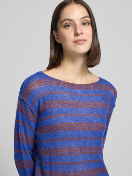 Frauenmodel trägt Relaxed Fit Strickpullover aus Lyocell-Mix Modell 'BODYROW' von American Vintage in Blau mit braunen Streifen, U-Boot-Ausschnitt, langärmlig, weiche Textur, Nahaufnahme Oberkörper. Damen Strickpullover, Lyocell-Mix mit Lanawoll-Anteil, überschnittene Schultern, Rückenlänge 44 cm, Ärmellänge 56 cm.