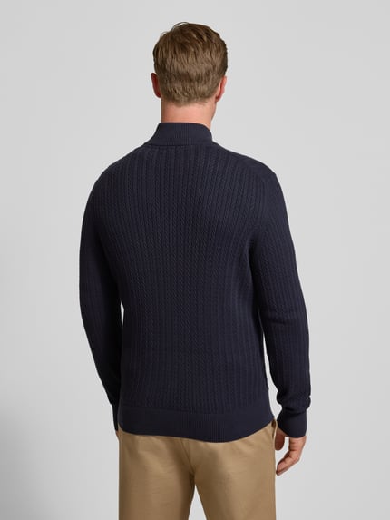 Männermodel trägt Strickjacke mit Reißverschluss von Christian Berg Men in Dunkelblau, reine Baumwolle, gerippte Abschlüsse, Rückenlänge 70 cm, Ganzkörperansicht Rückansicht.
