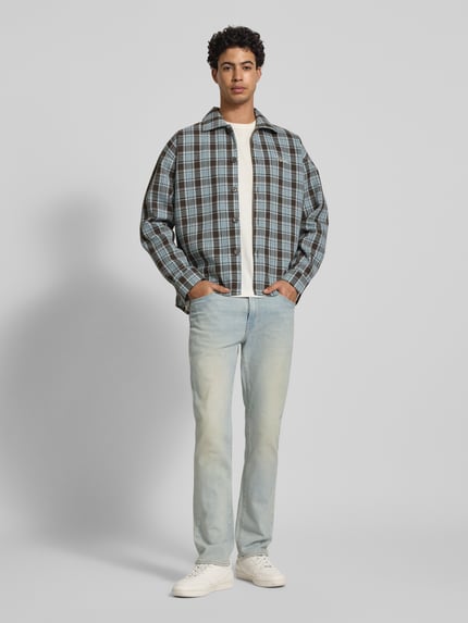 Męski model nosi Slim Fit Jeans im 5-Pocket-Design od LEVI'S®, mieszanka bawełny elastycznej, jasnoniebieskie, zapięcie na guzik i zamek błyskawiczny, szerokość w rozmiarze 32/32: 41 cm, długość wewnętrzna nogawki 78 cm, widok całej sylwetki z przodu.