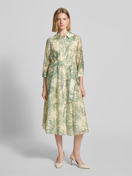 Frauenmodel trägt Figurumschmeichelndes Freizeitkleid aus Lyocell-Mix von s.Oliver BLACK LABEL mit Allover-Muster in Grün-Beige, Knopfleiste, Taillengürtel, V-Ausschnitt, Midi-Länge, 3/4-Arm, Materialverarbeitung Popeline, Viskose-Mix, Ganzkörperansicht von vorne.