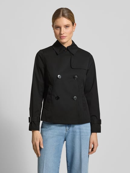 Frauenmodel trägt schwarzen Trenchcoat mit Knopfverschluss von MICHAEL Michael Kors, Regular Fit, zweireihig, Umlegekragen, Ganzkörperansicht von vorne.