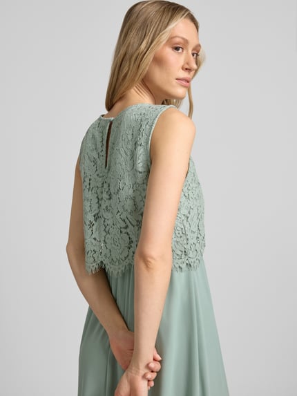 Frauenmodel trägt Maxikleid mit rückseitigem Schlüsselloch-Ausschnitt von Vila, mintgrüner Baumwoll-Mix, Spitze, Ganzkörperansicht Rückansicht.