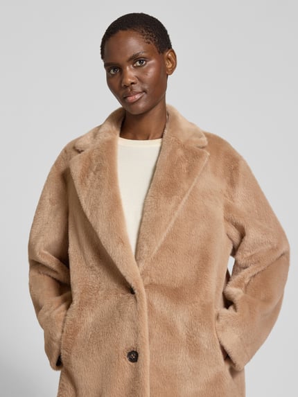 Frauenmodel trägt Teddymantel mit seitlichen Eingrifftaschen von S. OLIVER BLACK LABEL, beige, Fleece, Strukturmuster, Nahaufnahme Oberkörper.