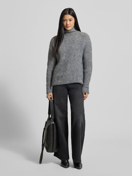 Frauenmodel trägt Strickpullover mit Stehkragen und überschnittenen Schultern von Milano Italy, grau meliert, Material-Mix mit Mohair, Ganzkörperansicht von vorne.