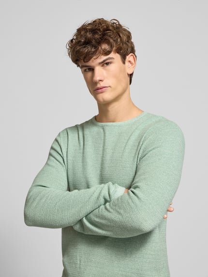 Männermodel trägt mintgrünen Herren Strickpullover mit geripptem Rundhalsausschnitt Modell 'GEORGE' von Jack & Jones aus Baumwoll-Mix, lockerer Schnitt, Nahaufnahme Oberkörper.