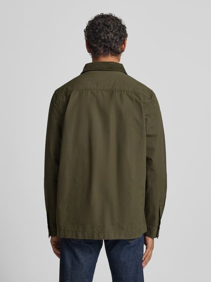 Męski model nosi Regular Fit Hemdjacke aus reiner Baumwolle od Barbour, efekt: jednolity kolor, krój regular fit, wykładany kołnierz z obszyciem ze sztruksu, listwa guzikowa, wyhaftowane logo, długi rękaw z mankietami, wpuszczane kieszenie, bawełna, całkowity widok z tyłu.