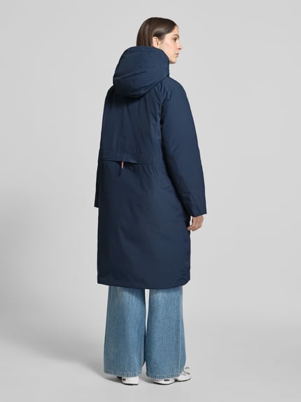 Frauenmodel trägt Parka mit echter Daune und 10.000 mm Wassersäule von Peak Performance, dunkelblau, glatte Textur, Ganzkörperansicht Rückansicht. Modell 'TREELINE', Regular Fit, Kapuze, verdeckter Reißverschluss, Rückenlänge 108 cm, Schulterbreite 53 cm, Brustweite 62 cm, Ärmellänge 49 cm.