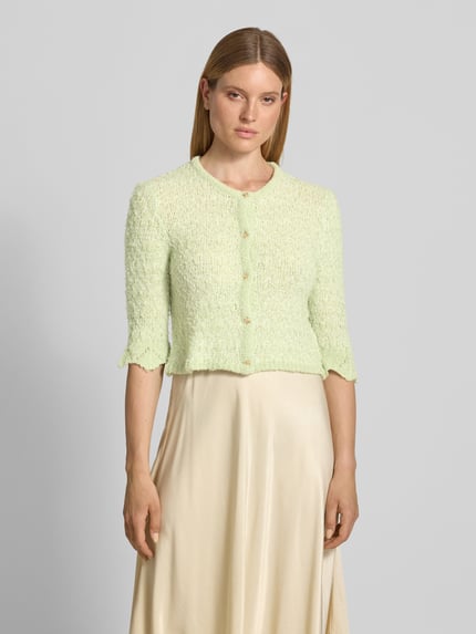 Frauenmodel trägt Strickjacke aus Lanawolle-Mix mit 3/4-Arm von Christian Berg Woman in hellem Grün, Struktur mit Knopfleiste, Slim-Fit, Rundhalsausschnitt, zeigt Damen Strickjacke mit Stretch-Anteil, Nahaufnahme Oberkörper.
