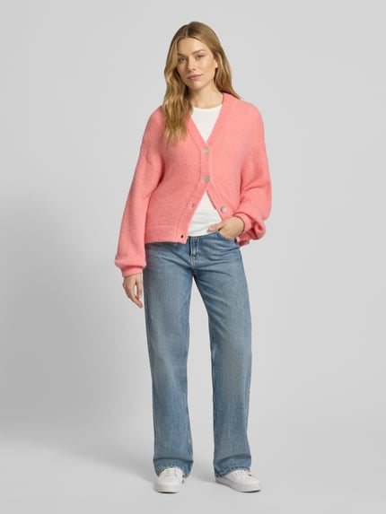 Frauenmodel trägt Strickjacke mit V-Ausschnitt Modell 'Petrinelle Hope' von MSCH Copenhagen in Rosa, Relaxed Fit, Ganzkörperansicht von vorne.