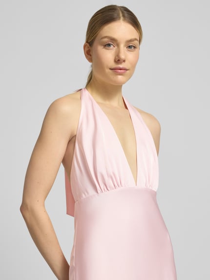 Frauenmodel trägt Maxikleid mit V-Ausschnitt Modell 'Dascha' von JOOP! aus rosafarbenem Satin, körpernaher Schnitt, Nahaufnahme Oberkörper.