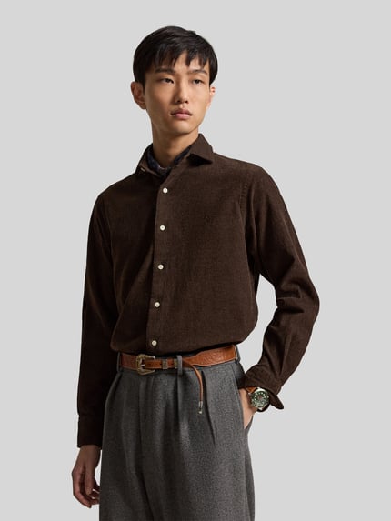 Mannelijk model draagt Custom Fit Freizeithemd aus Baumwollmix van Polo Ralph Lauren in effen bruin met knoopsluiting, lange mouwen en logo-stiksel, katoenmix materiaal, bovenlichaam close-up van voren.