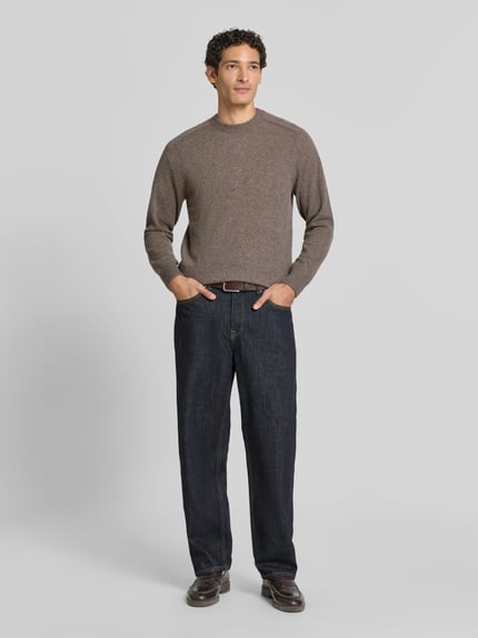 Männermodel trägt Regular Fit Strickpullover aus reinem Kaschmir von FTC Cashmere in Braun, Stehkragen, gerippte Abschlüsse, Ganzkörperansicht von vorne.