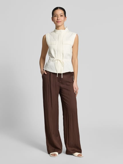 Frauenmodel trägt Stoffhose aus Lyocell-Mix mit Schnürung von Jake*s Casual in Braun, Wide Leg, kombiniert mit hellem Oberteil, glatte Textur, Ganzkörperansicht von vorne.