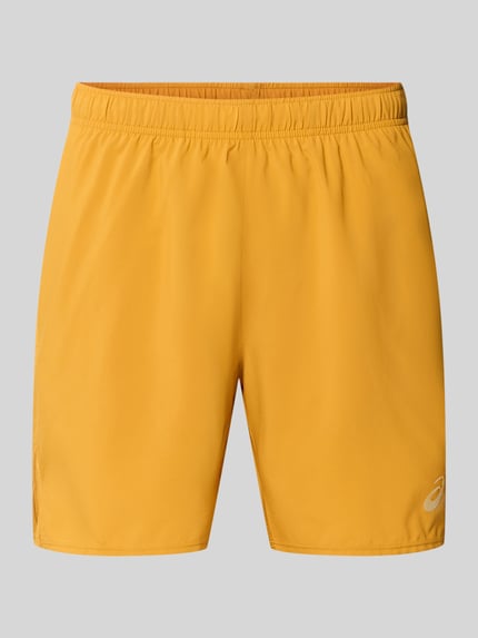 Produktfoto, Regular Fit Shorts mit integriertem Slip Modell 'Core' von ASICS TIGER in Gelb, elastischer Bund, Logo-Print, glatte Textur.
