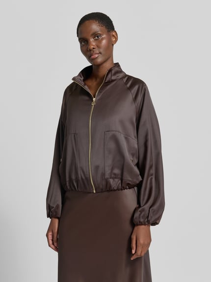 Frauenmodel trägt Regular Fit Blouson aus Viskose-Mix von s.Oliver BLACK LABEL in Braun mit glänzender Oberfläche, Nahaufnahme Oberkörper. Damen Bomberjacke / Blouson.