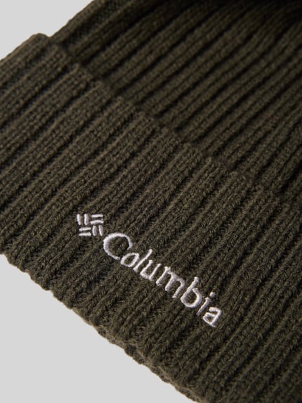 Produktfoto, dunkelgrüne Mütze in Strick-Optik Modell 'COLUMBIA' von Columbia mit weißem Logo-Detail und fixiertem Saum, strukturierte Rippen.