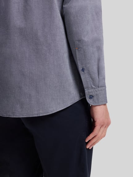 Männermodel trägt Regular Fit Freizeithemd aus Oxford-Baumwolle Modell 'RICKERT' von BOSS Orange, melierte Optik, Nahaufnahme Oberkörper.