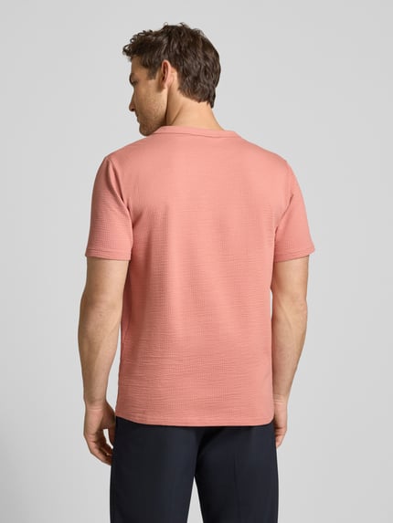 Mężczyzna nosi Regular Fit T-Shirt aus Baumwoll-Mix Modell 'SANDER' von SELECTED HOMME w kolorze różowym, faktura seersucker, krótki rękaw, widok całej sylwetki od tyłu