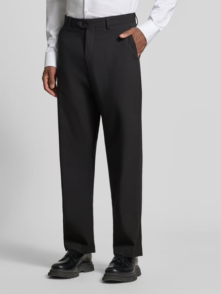 Männermodel trägt schwarze Loose Fit Anzughose mit Gürtelschlaufen Modell 'LOOSE-LIAM' von Selected, Herrenmode, Ganzkörperansicht von vorne.