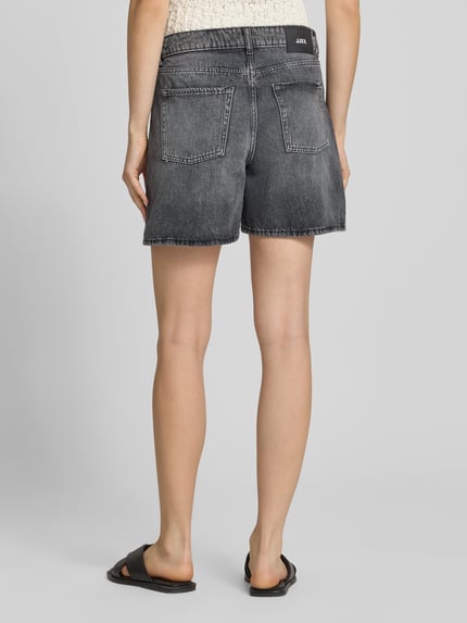 Frauenmodel trägt Shorts in Denim-Optik Modell 'Seville' von JJXX, reine Baumwolle, 5-Pocket-Design in Grau, Ganzkörperansicht Rückansicht.