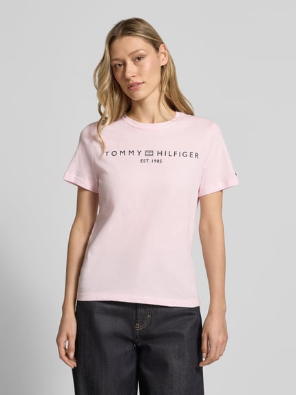 Frauenmodel trägt Regular Fit T-Shirt aus reiner Baumwolle von Tommy Hilfiger in Optik: Unifarben, Logo-Detail, Label-Schriftzug, Rundhals, Kurzarm, Jersey; Nahaufnahme Oberkörper.