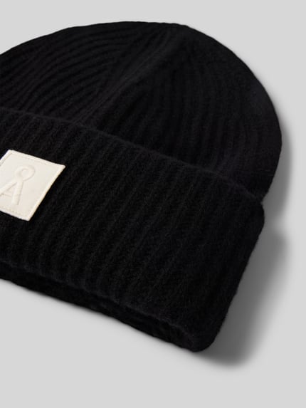 Produktfoto, schwarze Mütze aus reiner Wolle Modell 'ICONIC Å WOOL' von ARMEDANGELS, gerippte Textur, rechteckiges Label, Damen Mütze
