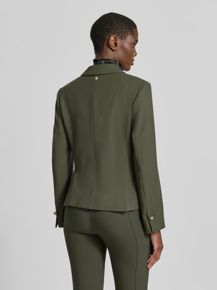 Frauenmodel trägt Slim Fit Blazer mit Reverskragen und Pattentaschen von Marc Cain in Oliv, Material-Mix, Rückansicht, Ganzkörperansicht.