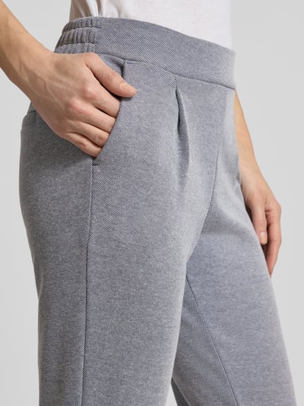 Frauenmodel trägt Slim Fit Stoffhose mit elastischem Bund Modell 'Kate' von ICHI aus Baumwoll-Mix mit Paspeltaschen, Nahaufnahme Oberkörper.