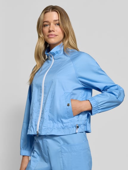 Vrouwenmodel draagt Regular Fit Jacke mit Stehkragen van Marc Cain in lichtblauw, elastische katoenmix, zijzakken met drukknoop, tweewegrits, tunnelkoord in taille, elastische mouwuiteinden, voorkant, halfhoge opname
