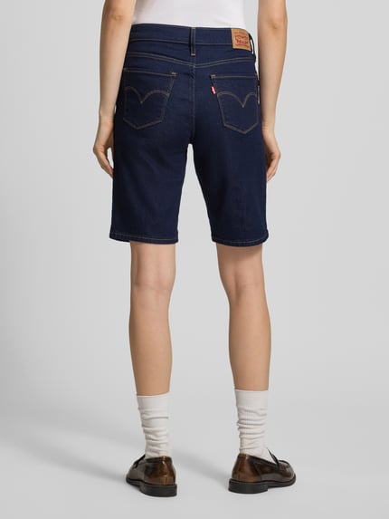 Frauenmodel trägt Bermuda mit 5-Pocket-Design von Levi's® 300 in Denim-Optik, Slim-Fit Passform aus Baumwoll-Mix, Ganzkörperansicht Rückansicht.