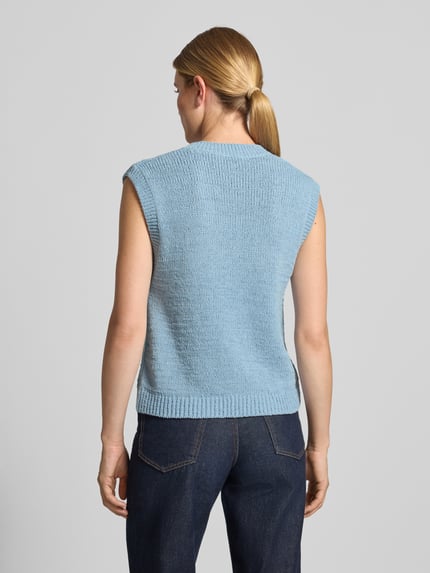 Frauenmodel trägt Regular Fit Pullunder aus reiner Baumwolle Modell 'ICONIC A' von ARMEDANGELS in Hellblau, grob gestrickte Struktur, Ganzkörperansicht Rückansicht. Damen Pullunder von ARMEDANGELS.