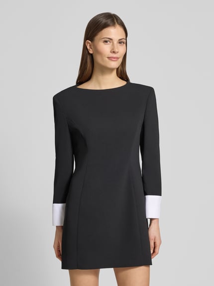 Vrouwenmodel draagt Minikleid mit Rundhalsausschnitt Modell 'TALISSO' van Marella, getailleerde fit, zwarte stof met witte manchetten, ronde hals, rugrits, ruglengte maat 36: 79 cm, borstwijdte 46 cm, mouwlengte 54 cm, vooraanzicht bovenlichaam close-up.